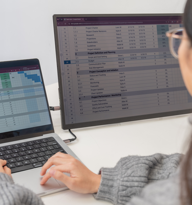 Woman using Eazeye Monitor 2.0 indoors, working on a spreadsheet with its paper-like display and anti-glare properties for optimal comfort.