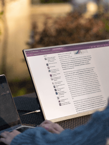 Woman using Eazeye Monitor 2.0 outdoors, showcasing paper-like display and anti-glare properties for comfortable viewing.