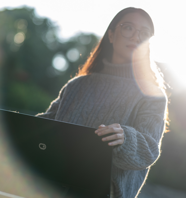 Woman demonstrating the Eazeye Monitor 2.0 outdoors, highlighting its ultra-high reflection™ and anti-glare features for optimal visibility in sunlight.