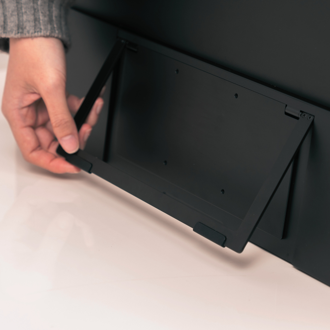 Close-up of woman setting up Eazeye Monitor 2 kickstand on white desk