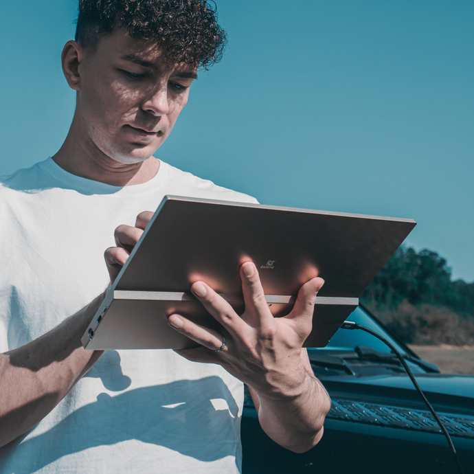 Man using Radiant monitor beside his car in the countryside, outdoor-readable reflective screen