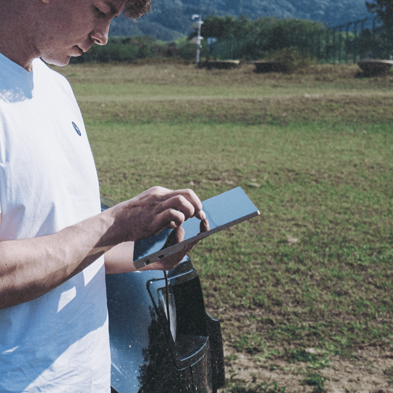 Man scrolling through content on the Radiant Monitor outdoors, enjoying clear visibility under natural lighting.