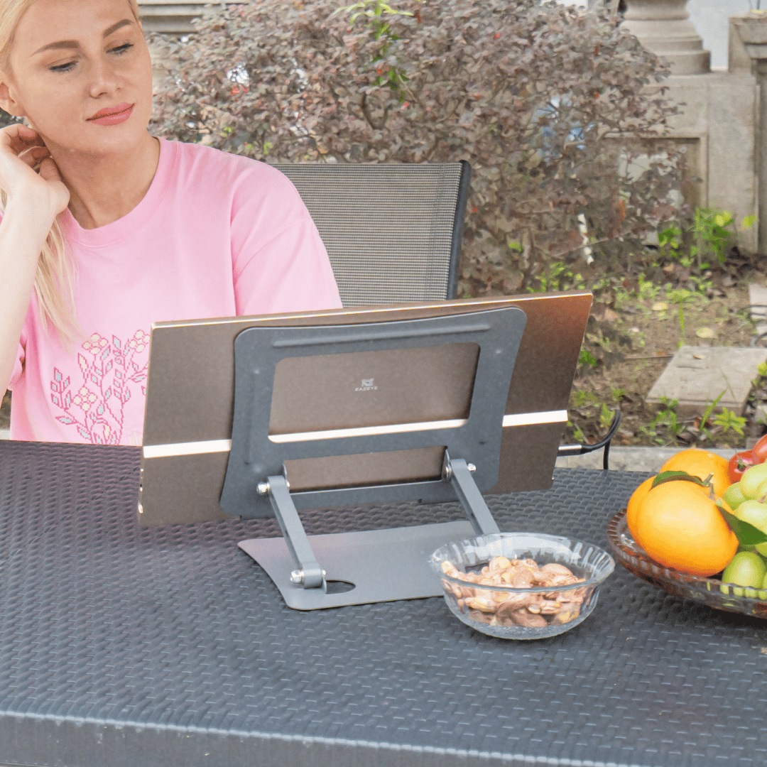 Woman enjoying entertainment on the Radiant Monitor while having lunch, with crystal-clear display and anti-glare technology perfect for casual use.