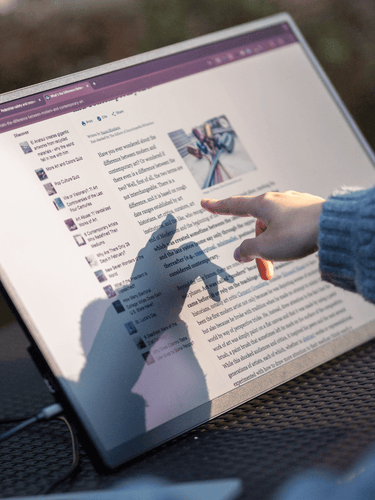 Woman pointing at Eazeye Monitor 2.0 screen, casting shadow to demonstrate its paper-like display in natural light.